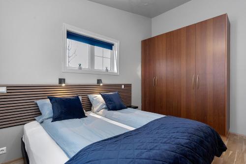 a bedroom with a large bed with a wooden headboard at Iceland Inn Lodge, entire place with hot tub. in Selfoss