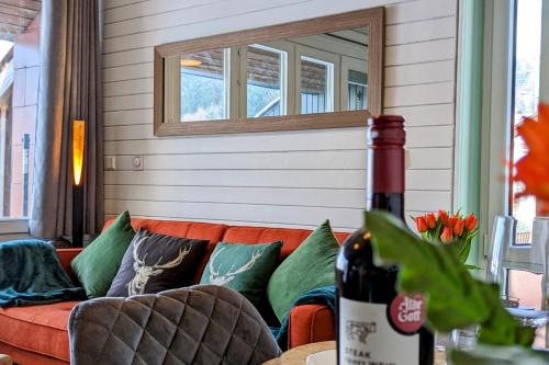 a couch in a room with a window and a bottle of wine at Black Forest Stay - Apartment Hirschperle in Sasbachwalden