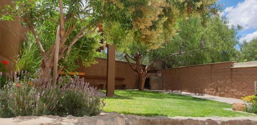 a garden with trees and a brick wall at La Casa de los Molles in Tilcara