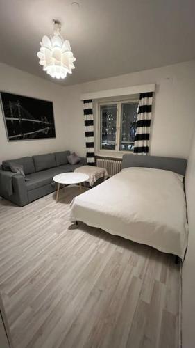 una camera con un letto bianco e un divano di Kallion helmi a Helsinki