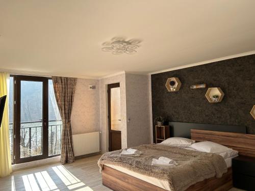 a bedroom with a bed and a large window at Oldtown Apartments in Mtskheta