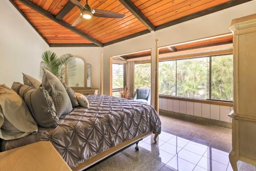 Kailua-Kona Home with Tropical Bar Walk to Beach! في كيلوا كونا: غرفة نوم بسرير ومروحة سقف