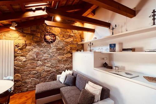 sala de estar con pared de piedra y sofá en Private Luxury, en Udine