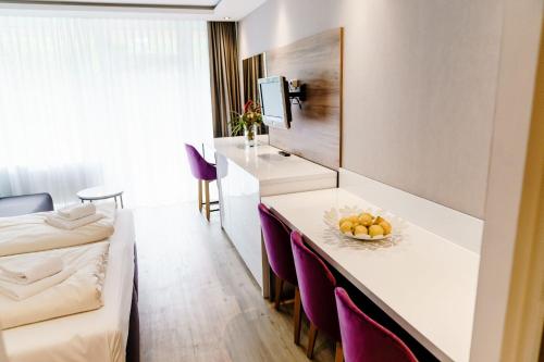 eine Küche und ein Wohnzimmer mit einem Tisch und lila Stühlen in der Unterkunft Appartements Am Kranichsee in Hahnenklee-Bockswiese
