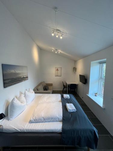 a bedroom with a large bed and a couch at Hartel House in Ollerup