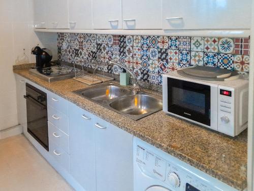 a kitchen with a sink and a microwave at Casa Miraflores in Seville