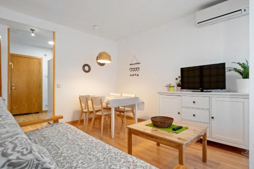 uma sala de estar com uma mesa e uma cozinha em Hauzify I Apartament Torremar em Torredembarra