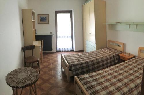 a hotel room with two beds and a table at Appartamento Cogolo con terrazza in Cogolo