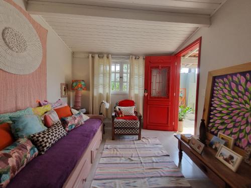 sala de estar con sofá y puerta roja en Casa decorada perto da Praia de Perequê - Ilhabela, en Ilhabela