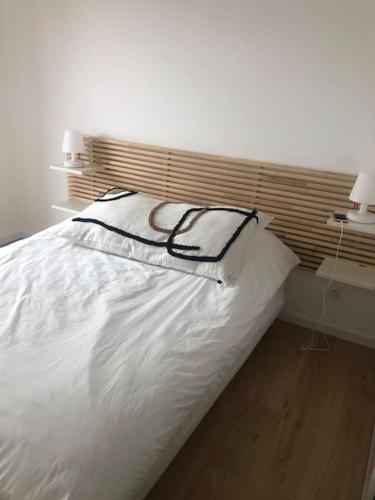 duże białe łóżko w sypialni z 2 lampami w obiekcie Maison La teste de Buch 3 chambres w mieście La Teste-de-Buch