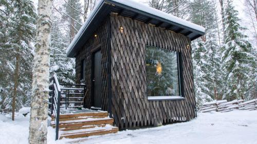 a small log cabin in the woods in the snow at Venejoen Piilo - Päre in Kontiolahti