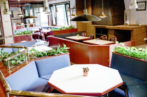 a restaurant with tables and chairs with plants on them at Appartements Am Kranichsee in Hahnenklee-Bockswiese