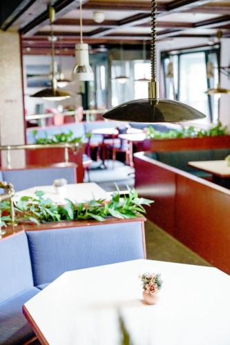 a restaurant with tables and chairs and pendant lights at Appartements Am Kranichsee in Hahnenklee-Bockswiese
