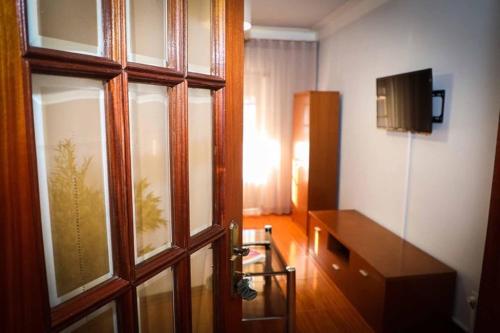 a room with a wooden door and a television at Casa Fundo de Vila in Manteigas