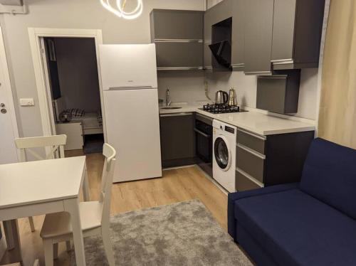 uma pequena cozinha com uma mesa e um sofá azul em Cosy, central apartment in Fatih ! em Istambul