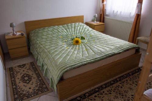 a bedroom with a bed with a flower on it at Prenočišča Jezero in Gorenje Jezero