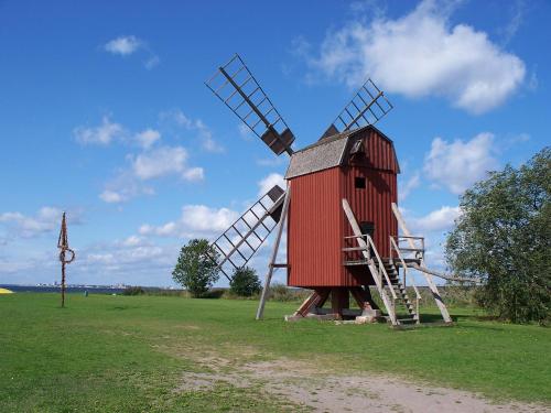 a large red windmill in a field with a sky at Ferienhaus mit Kamin in Småland für 6 Personen in Järnforsen