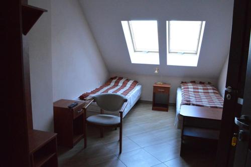 - une chambre avec 2 lits, un bureau et une fenêtre dans l'établissement Ośrodek SUDETY, à Pokrzywna