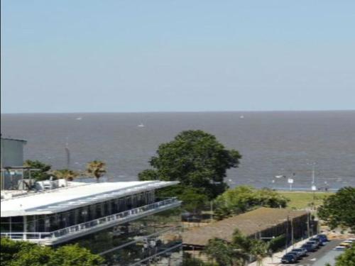un edificio junto al océano con coches estacionados frente a él en MONOAMBIENTE VISTA AL RIO, en Florida