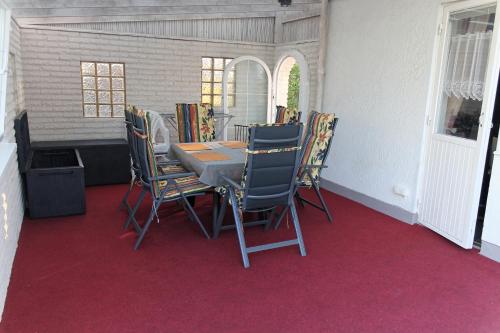 a dining room with a table and chairs on red carpet at Ferienhaus mit Kamin in Småland für 6 Personen in Järnforsen