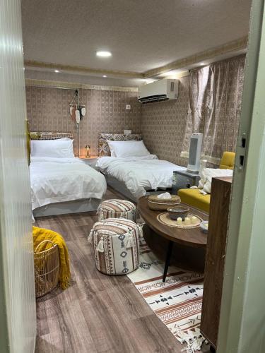 a hotel room with two beds and a table at Four caravan in AlUla