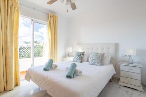 a bedroom with a white bed with two stuffed animals on it at Casa Chloe in Nerja