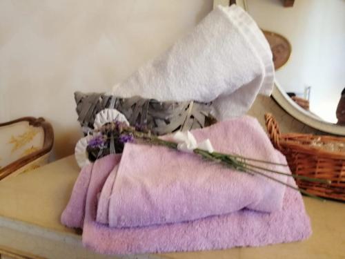 a pile of towels and flowers on a bed at Casa degli Ulivi in Tolentino