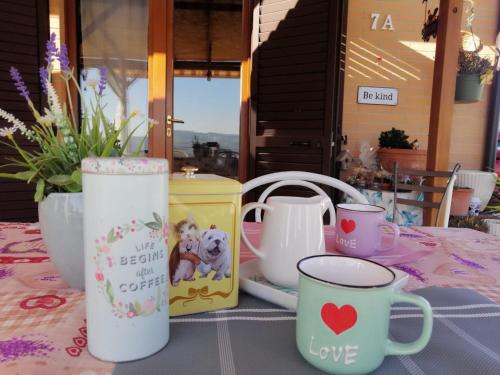 a table with cups and other items on it at Casa degli Ulivi in Tolentino