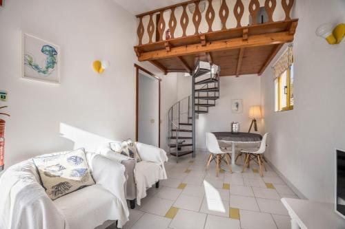 ein Wohnzimmer mit einer Treppe, einem Tisch und Stühlen in der Unterkunft Apartamento Amarelo in Odeceixe