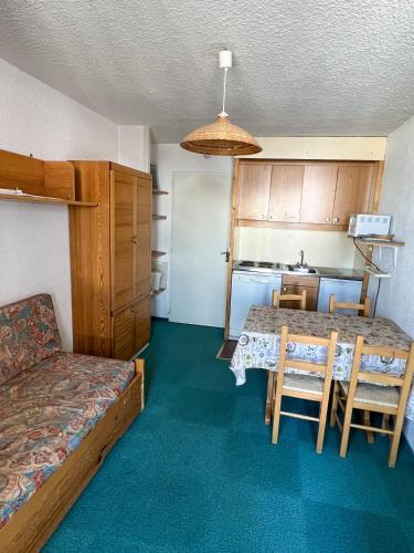Cette chambre comprend une table, un lit et une cuisine. dans l'établissement Charming studio 3 persons, à Val Thorens