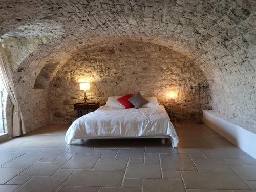 une chambre avec un lit dans un mur de pierre dans l'établissement Gite de charme, bastide avec piscine, à Sainte-Juliette