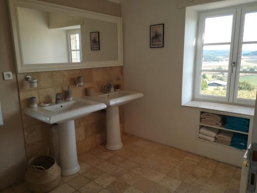 une salle de bain avec deux lavabos et un miroir dans l'établissement Gite de charme, bastide avec piscine, à Sainte-Juliette