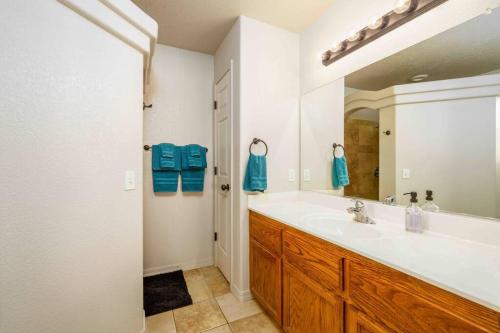 a bathroom with a sink and a large mirror at Havasu lake house 4 BR & 3 BA w/pool & hot tub in Lake Havasu City
