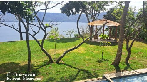 a garden with a gazebo next to a body of water at El Guayacán in Valle la Laguna