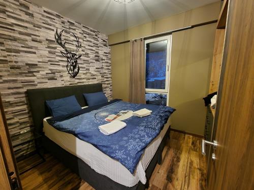 a bedroom with a bed with towels on it at Mavrovo ski apartment in Mavrovo