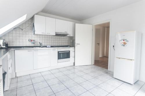 a kitchen with white cabinets and a refrigerator at Eindrucksvolles Gruppen– und Monteursloft in Edingen-Neckarhausen