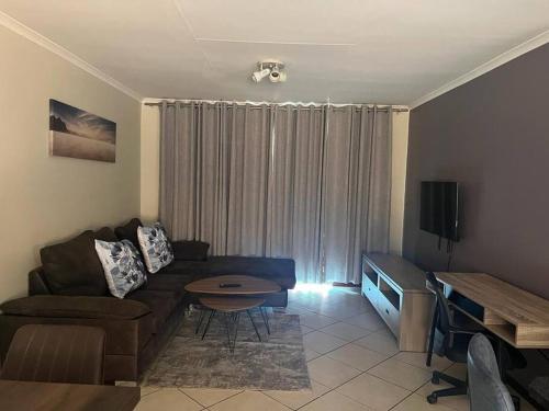 a living room with a couch and a table at Centurion: Chilled Townhouse in Centurion