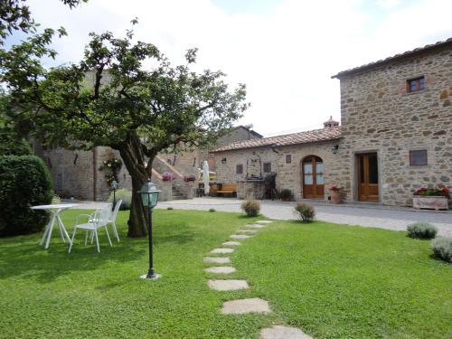 a garden with a table and a tree and a building at Casale l'Antico Carro in Cortona
