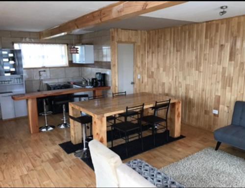 eine Küche mit einem großen Holztisch und Stühlen in der Unterkunft Cabañas Tinajas hidromasaje Chanlelfu in Puyehue