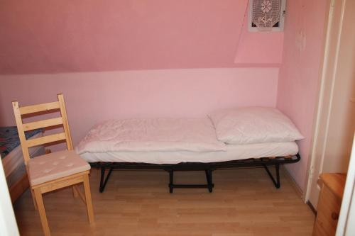 a small bed in a room with a chair at Ferienhaus mit Kamin in Småland für 6 Personen in Järnforsen