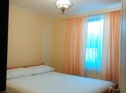 1 dormitorio con cama blanca y ventana en Full Equipada La Herradura, en Coquimbo