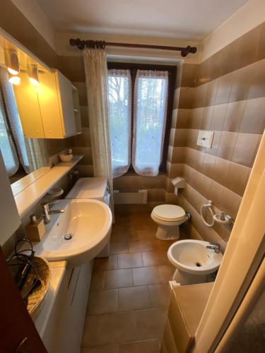 uma pequena casa de banho com 2 WC e um lavatório em Trilocale accogliente con camino a pochi minuti da Madonna di Campiglio em Spiazzo