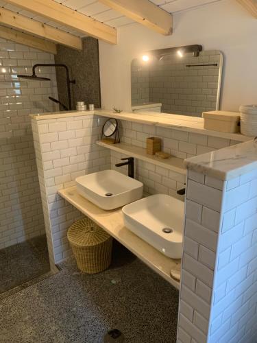 a bathroom with two sinks and a mirror at Casinha Revira Volta in Nesperal