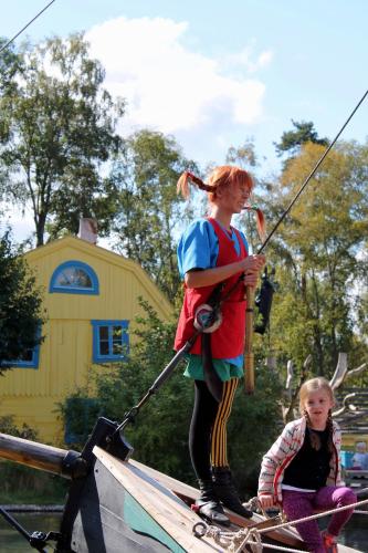 a young girl standing on a boat holding a fishing pole at Ferienhaus mit Kamin in Småland für 6 Personen in Järnforsen