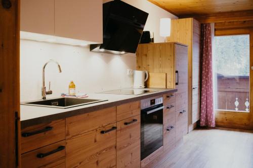 a kitchen with wooden cabinets and a sink at Bergbauernhof Pabulariu in Boden