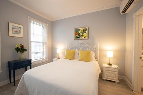 ein Schlafzimmer mit einem großen weißen Bett mit gelben Kissen in der Unterkunft Inn on Main Annapolis in Annapolis
