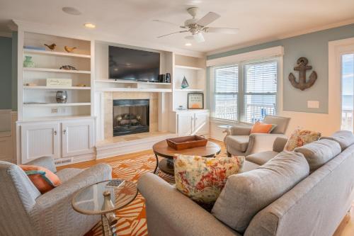 a living room with two couches and a fireplace at Oceanfront - Decks For Days in Kure Beach