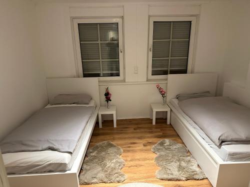 two beds in a room with two windows at Apartment for rent 2 in Celle