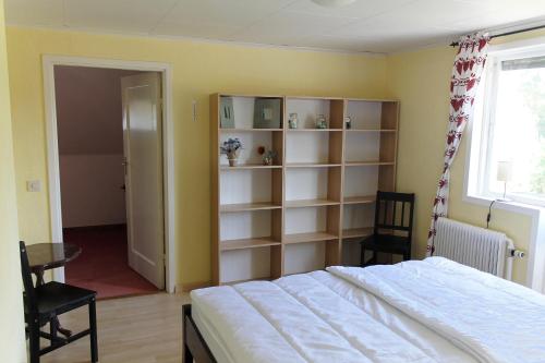 a bedroom with a bed and a book shelf at Ferienhaus mit Kamin in Småland für 6 Personen in Järnforsen