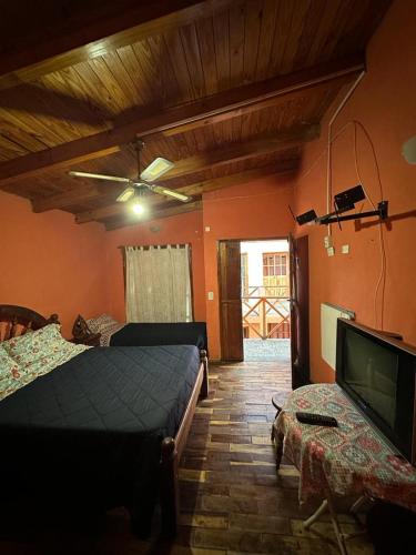 a bedroom with two beds and a flat screen tv at HOSPEDAJE TAFI in Tafí del Valle